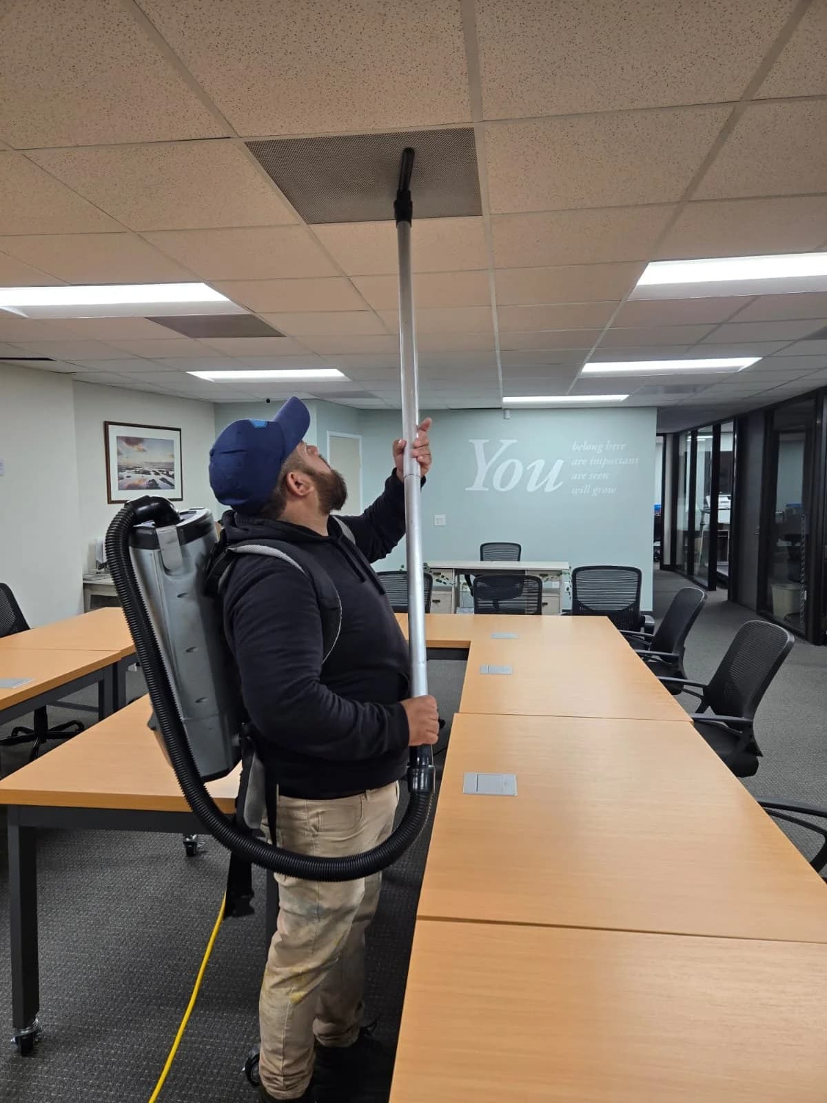 Oracle Group Services technician cleaning office ceiling vents
